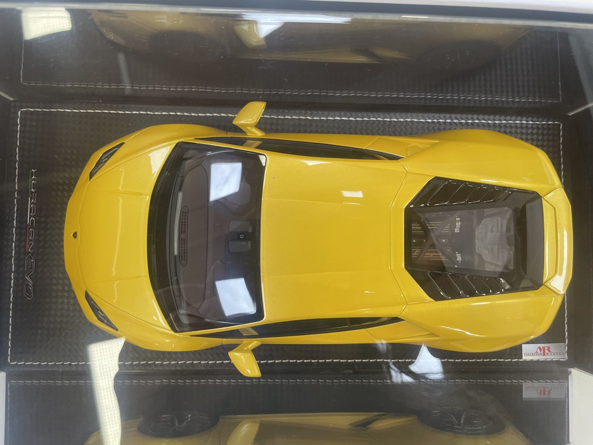 Lamborghini Huracán EVO 1:18 scale model car in display case on white surface, side view