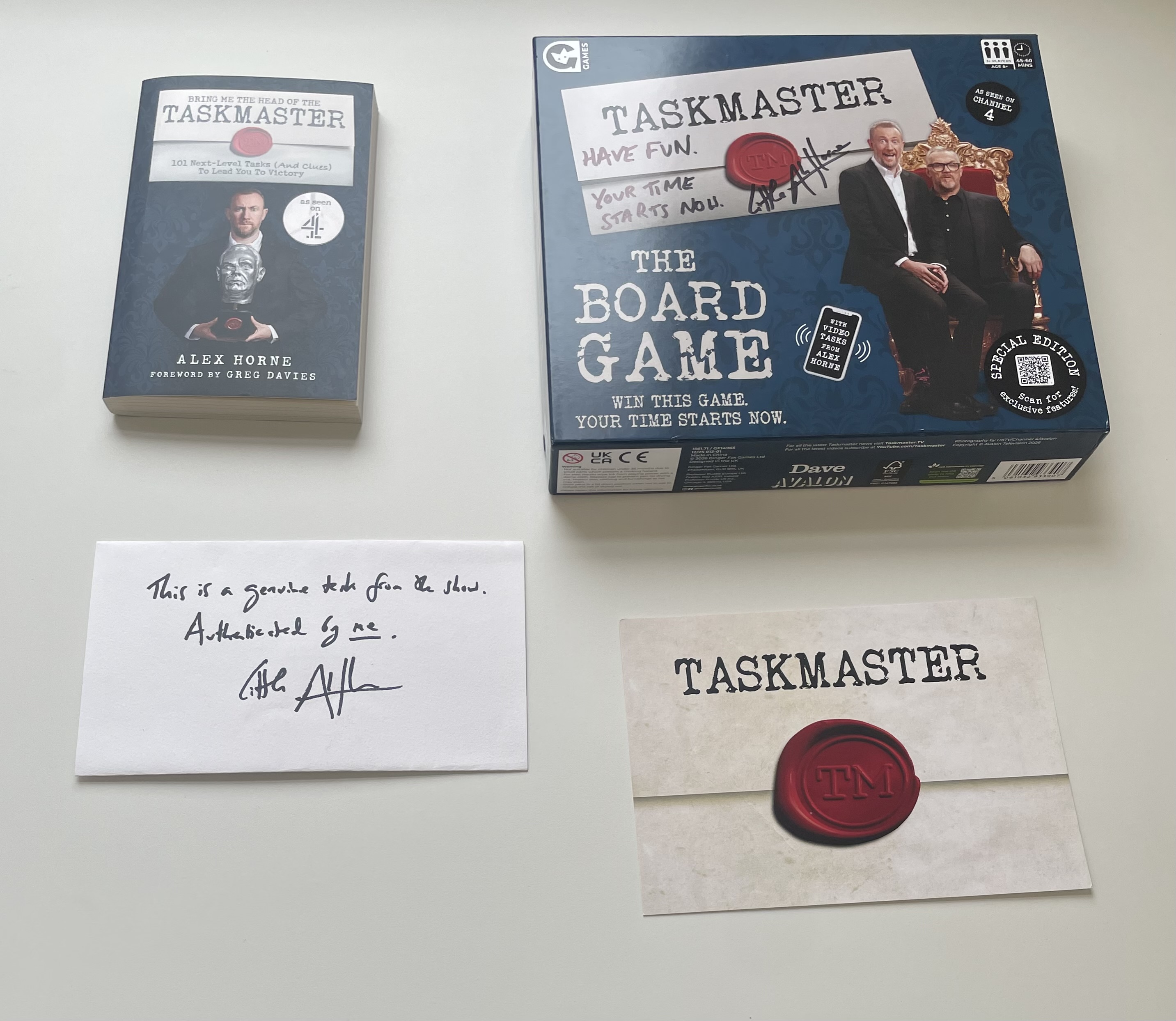 Taskmaster Board Game signed by Alex Horne, the Bring Me the Head of the Taskmaster book, a genuine sealed task card and handwritten authentication note